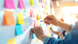 © alex - Creative team brainstorming new business strategies on a whiteboard filled with colorful sticky notes, fostering innovation and teamwork in a modern office