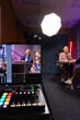© fizkes - Guest and host recording podcast or talk show, engaging in digital broadcasting, audio console and monitor showing camera angles, professional studio behind scenes. Live streaming, content production