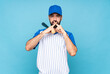 © luismolinero - Young man playing baseball over isolated blue background showing a sign of silence gesture