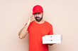 © luismolinero - Young man holding a pizza over isolated background with headache