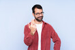 © luismolinero - Young caucasian man wearing corduroy jacket over blue background inviting to come with hand. Happy that you came