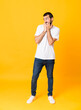 © luismolinero - Full-length shot of man with beard over isolated yellow background nervous and scared putting hands to mouth