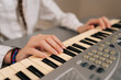 © dikushin - Close-up hands of unrecognizable young girl playing digital piano at home, learning music, practicing keyboard skills, enjoying musical education as hobby