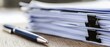© Olga Ко - Stapel von Geschäfts-Dokumenten mit Foldback-Klammern und einem Stift auf einem Holzschreibtisch. Konzept für Büroarbeit, Verträge und Verwaltung.