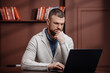 © wedmoments.stock - Businessman working remotely on laptop in modern office setting. Technology and work concept.