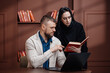 © wedmoments.stock - Professional man and woman sharing information with laptop and book in modern office. Business concept.