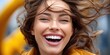 © NovaVision - Joyful woman with windblown hair laughing heartily with a bright white smile