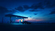 © pjjaruwan - Hydrogen fueling station at dusk with car refueling under dramatic blue sky, atmospheric lighting and empty forecourt
