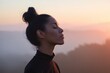 © Andrii Zastrozhnov - Young african female practicing mindful breathing at sunset with eyes closed profile silhouette against warm glowing horizon and tranquil landscape