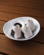 © Bastian - White plate holds three rice balls with seaweed