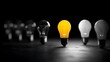 © Haider - A bright yellow light bulb standing out from a row of dim and dark bulbs