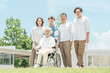 © buritora - A three-generation family visiting a senior care facility or hospital.