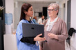© DC Studio - Hospital pharmacist guiding elderly caucasian woman with medications, treatments. Asian nursing assistant suggesting care regimens to patient. Physician using computer to care patient.