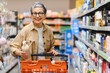 © Serhii - Mature woman smiling buying products in supermarket