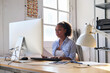 © Cristina Garcia - professional Black woman entrepreneur working on computer in home office