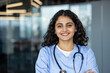 © Liubomir - Smiling indian nurse wearing scrubs holding stethoscope