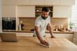 © La Famiglia - Young male cleaning kitchen countertop