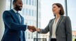 © Chandara - Two business professionals shaking hands in an office setting.