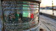 © MMCXIII - Close-up of a weathered and cracked nautical Fresnel lens on a vintage ship lantern with green and red navigation lights