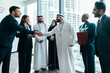 © oneinchpunch - Diverse business team shaking hands during corporate meeting in dubai