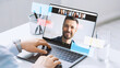 © Prostock-studio - Businessman sits at a white table and uses a laptop for an online meeting. He is focused on the screen with a video call. A glass of water is nearby.