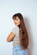 © verona_studio - Woman smiling and posing in casual fashion with long hair in a simple studio setting, capturing a joyful moment of self-confidence and happiness