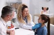 © New Africa - Endocrinologist in medical gloves examining girl's thyroid gland while her father supporting her at white desk in clinic