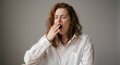 © Vyatcheslav - Tired young woman yawning with eyes closed. Exhausted female in white shirt covering mouth with hand