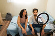© AntonioDiaz - Young couple creating social media content in their first apartment, making ends meet and living on a budget