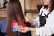 © Pixel-Shot - Female hairdresser with hair color palette and client in beauty salon, back view