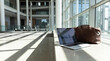 © Jonathan - Modern workspace with laptop and travel bag, bathed in natural light, ready for remote work or a business trip.