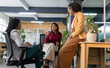 © Wavebreak Media - Diverse female coworkers discussing project ideas at open-plan office corner with coffee mug