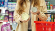 © Pavel - Woman comparing canned pet food products in store, choosing between options before purchase, consumer decision making in supermarket or pet shop, selection of canned or pet food products