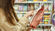 © Pavel - Woman Reading Pet Food Label In Supermarket. Responsible Pet Owner Checking Ingredients Before Purchase. Pet Care And Shopping Concept.
