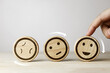 © Midnight Studio - A rotating wooden panel displaying changing facial expressions. concept of attitudes towards positive change, improving customer service, and increasing satisfaction in the evaluation process.