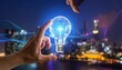 © bento - A hand reaches toward a glowing digital light bulb floating above a cityscape at dusk, symbolizing creativity, innovation, and technological advancement.