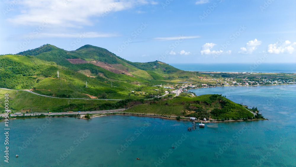 Aerial view of the tranquil lagoon meeting the verdant hills under a ...