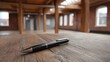 © Bussakon - A black pen rests on a rustic wooden floor inside a spacious industrial loft with exposed beams