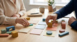 © solom - close up of male and female professional hands moving colorful wooden shapes and cards on office desk for agile project management scrum planning and creative business strategy
