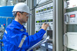 © reewungjunerr - Electrical engineer woman checking voltage at the Power Distribution Cabinet in the control room,preventive maintenance Yearly,Thailand Electrician working at company