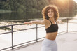 © anatoliycherkas - Young woman practicing warrior pose by the lake at sunset, enjoying fitness and mindful wellness outdoors