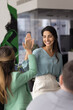 © fizkes - Smiling businesswoman team leader supporting encouraging motivating female coworker with high five praising giving achievement recognition celebrating success on casual staff group meeting in office