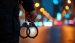 © Viktor - Police officer holds handcuffs in hand at night city street with blurred lights. Metal restraint implies arrest justice and law enforcement duty. Symbol of authority and security.