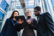© Westend61 - Business colleagues collaborating outdoors with tablet in urban setting