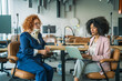 © Miljan Živković - Businesswoman with neck brace discussing with colleague in modern office