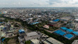 © AmazingAerialAgency - Aerial view of industrial buildings and residential areas intermingle under a vast sky, creating a textured urban mosaic, Ogba, Lagos, Nigeria.