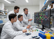 © logonv - Scientist and student researchers in laboratory analyzing dna sequence on monitor. Professional team working with molecular model. Innovative medical research and biology science technology.
