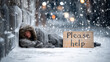 © ALA - A homeless person with a crumpled coat, sleeping beside a wall with a sign saying 'Please help,' as the snow gently falls