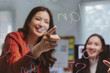 © amnaj - Young asian businesswomen collaborating and sharing ideas during a strategic planning meeting in a modern office environment