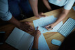 © peopleimages.com - Graphs, hands and team with documents in office at night for company report, KPI stats or performance. Analyst, people and data analysis for finance forecasting, pointing and budget strategy on above